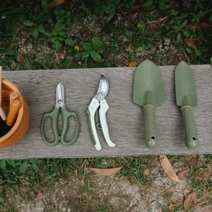 Herramientas de jardinería: guantes, tijeras de podar y pala de mano