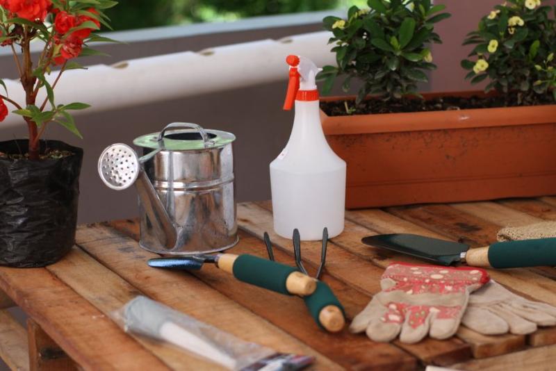 Guantes de jardinería junto a otras herramientas
